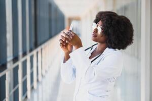 africano americano fêmea médico segurando seringa com injeção foto