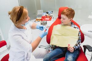 fêmea dentista e criança dentro uma dentista escritório foto