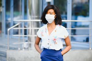 jovem voluntária afro-americana usando máscara facial ao ar livre. quarentena de coronavírus e pandemia global. foto