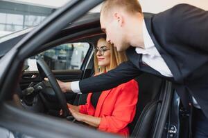 o negócio mulher compra uma carro às uma carro concessionária. conceito do feliz o negócio pessoas foto