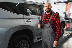 masculino mecânico trabalhando às uma reparar fazer compras e segurando Ferramentas foto