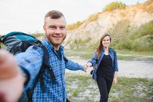 casal com mochilas levar selfie foto sobre montanha panorama caminhada, jovem homem e mulher em caminhar turistas aventura atividade