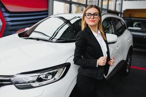 o negócio mulher compra uma carro às uma carro concessionária foto