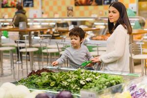 mãe e criança compras às agricultores mercado para frutas e legumes foto