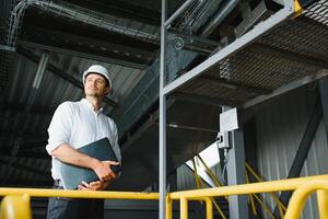 feliz masculino industrial técnico dentro uma fábrica foto