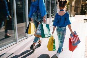 oferta, consumismo e pessoas conceito - feliz jovem mulheres dela Dauther com compras bolsas caminhando cidade rua. foto