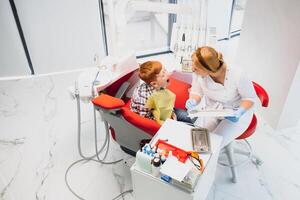 fêmea dentista e criança dentro uma dentista escritório foto