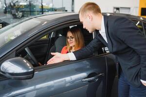 o negócio mulher compra uma carro às uma carro concessionária. conceito do feliz o negócio pessoas foto