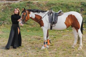 retrato do jovem bonita alegre mulher com cavalo às verão foto