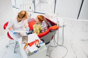 pequeno Garoto tendo dele dentes examinado de uma dentista foto