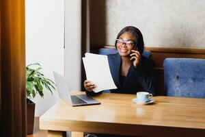 pensativo Preto empresária usando tábua computador dentro café fazer compras foto