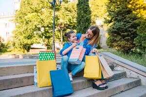 oferta, consumismo e pessoas conceito - feliz jovem mulheres dela Dauther com compras bolsas caminhando cidade rua foto