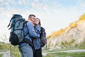 feliz romântico casal homem e mulher Viajantes com mochila segurando mãos montanhismo viagem estilo de vida e relação amor conceito montanhas panorama em fundo foto