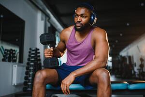 homem exercício com halteres às uma academia, horizontal tomada. foto