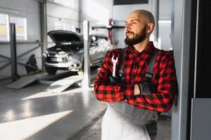 masculino mecânico trabalhando às uma reparar fazer compras e segurando Ferramentas foto