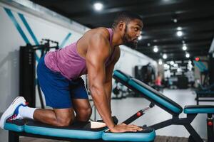 peso Treinamento africano fazendo musculação dentro academia. foto