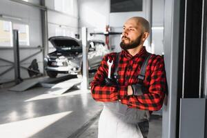 masculino mecânico trabalhando às uma reparar fazer compras e segurando Ferramentas foto