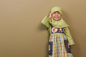 a indonésio pequeno menina vestindo hijab pano muito animado foto