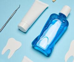 enxaguatório bucal, pasta de dentes tubo, dental fio dental em uma azul fundo, oral higiene foto