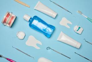enxaguatório bucal, pasta de dentes tubo, dental fio dental e médico espelho em uma azul fundo, oral higiene. foto