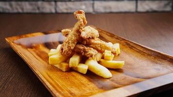 frango dedos e fritas isolado em de madeira borda lado Visão em mesa velozes Comida foto