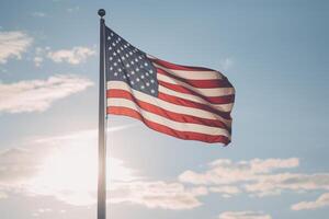 ai gerado a americano bandeira suspensão contra uma Claro céu sobre uma patriota dia memorial local. generativo ai foto