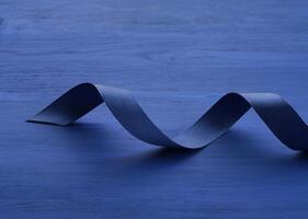 sofisticado Sombrio azul cetim fita em azul de madeira fundo. foto