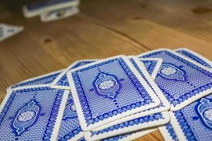 cartas de jogar azuis na mesa de madeira durante o jogo. foto