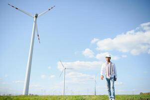 engenheiro Índia homem trabalhando às moinho de vento Fazenda gerando eletricidade limpar \ limpo energia. vento turbina Fazenda gerador de alternativo verde energia. ásia engenheiro verificação ao controle elétrico poder foto