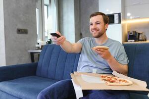 homem comendo pizza tendo uma Leve embora às casa relaxante em repouso foto