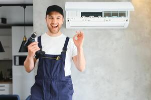 feliz masculino técnico reparação ar condicionador. foto