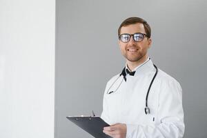 retrato do sorridente médico dentro uniforme em pé dentro remédio clínica corredor foto