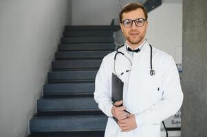 médico com estetoscópio em escadas dentro hospital. espaço para texto foto