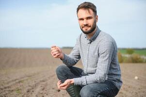 uma agricultor dentro chuteiras trabalho dentro uma campo semeado dentro Primavera. a agrônomo anda em a terra, avaliando uma arado campo dentro outono. agricultura. foto