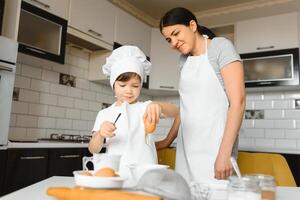 feliz família. mãe ensino dela filho quão para cozinhando bolo cardápio dentro manhã. saudável estilo de vida conceito.. cozimento Natal bolo e cozinhar conceito foto