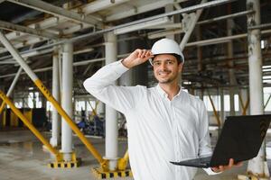 feliz masculino industrial técnico dentro uma fábrica foto