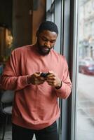 retrato jovem Preto homem de negocios falando em Móvel telefone. foto