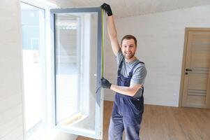 a trabalhador instalando e verificação janela dentro a casa. conceito do Novo modular casas. foto