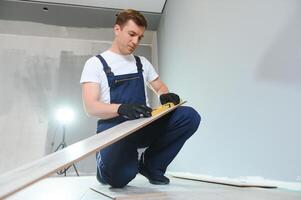 homem instalando Novo laminado de madeira chão foto