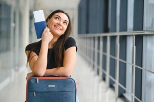 turismo, feriado, férias, infância e transporte conceito - sorridente pequeno menina com viagem saco sobre aeroporto fundo foto