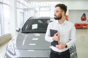 sorridente, amigáveis carro vendedor em pé dentro carro salão. foto