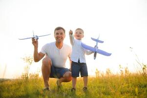 do pai dia. Papai e bebê filho jogando juntos ao ar livre avião foto