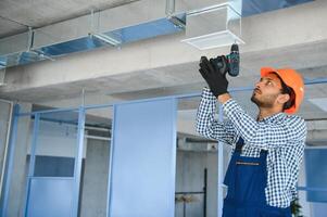 hvac Serviços - indiano trabalhador instalar canalizado tubo sistema para ventilação e ar condicionamento dentro casa foto
