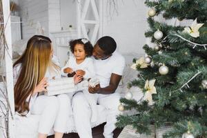 feliz multirracial família com presentes às Natal foto