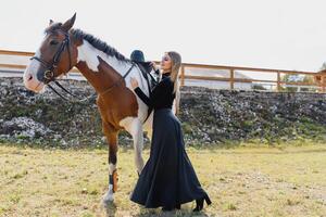 elegante retrato do uma lindo jovem mulher e cavalo foto