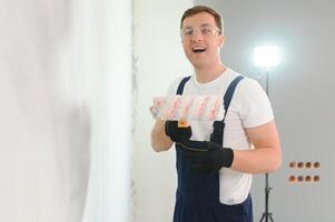 reparar, construção e casa conceito - fechar acima do masculino dentro luvas segurando pintura rolo foto