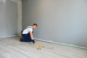 homem instalando Novo laminado de madeira chão foto