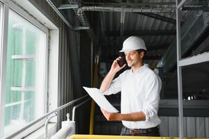 feliz masculino industrial técnico dentro uma fábrica foto