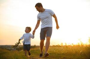 do pai dia. Papai e filho jogando juntos ao ar livre em uma verão. feliz família, pai, filho às pôr do sol. foto