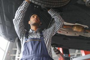 indiano feliz auto mecânico dentro azul terno. foto